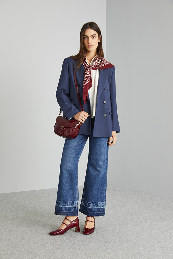 Modella indossa giacca blu con denim, scarpe e borsa bordeaux.