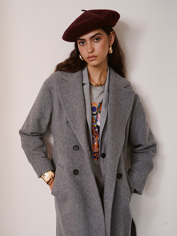 Modella indossa cappotto grigio con basco bordeaux.